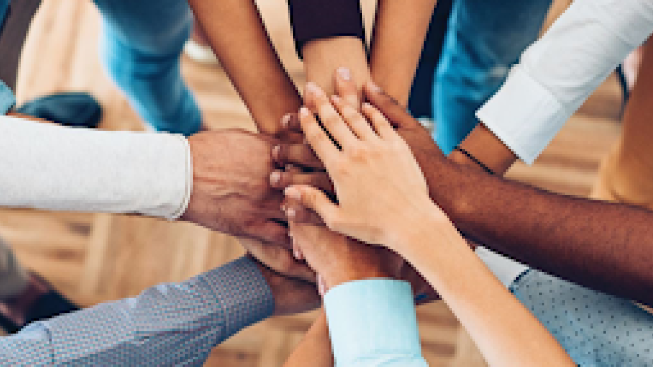 hands of many people stacked on top of each other
